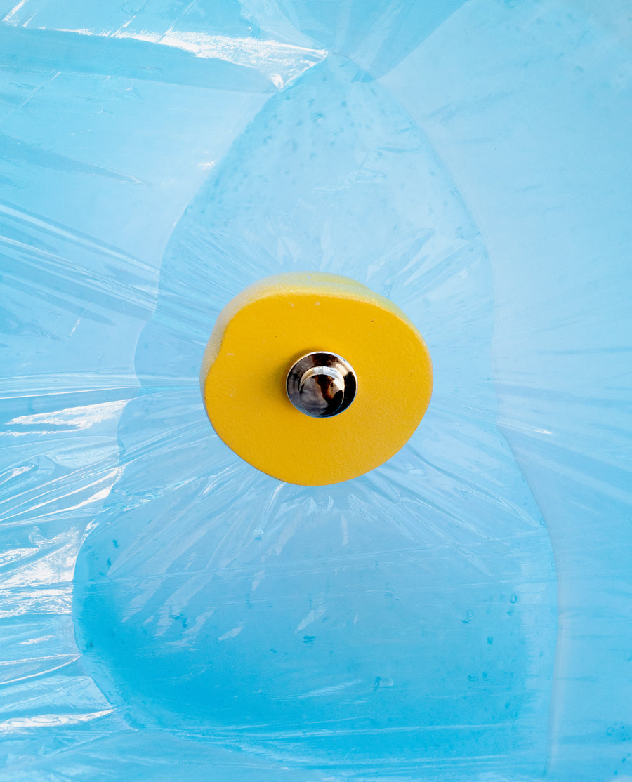 a yellow frisbee is in the blue water 