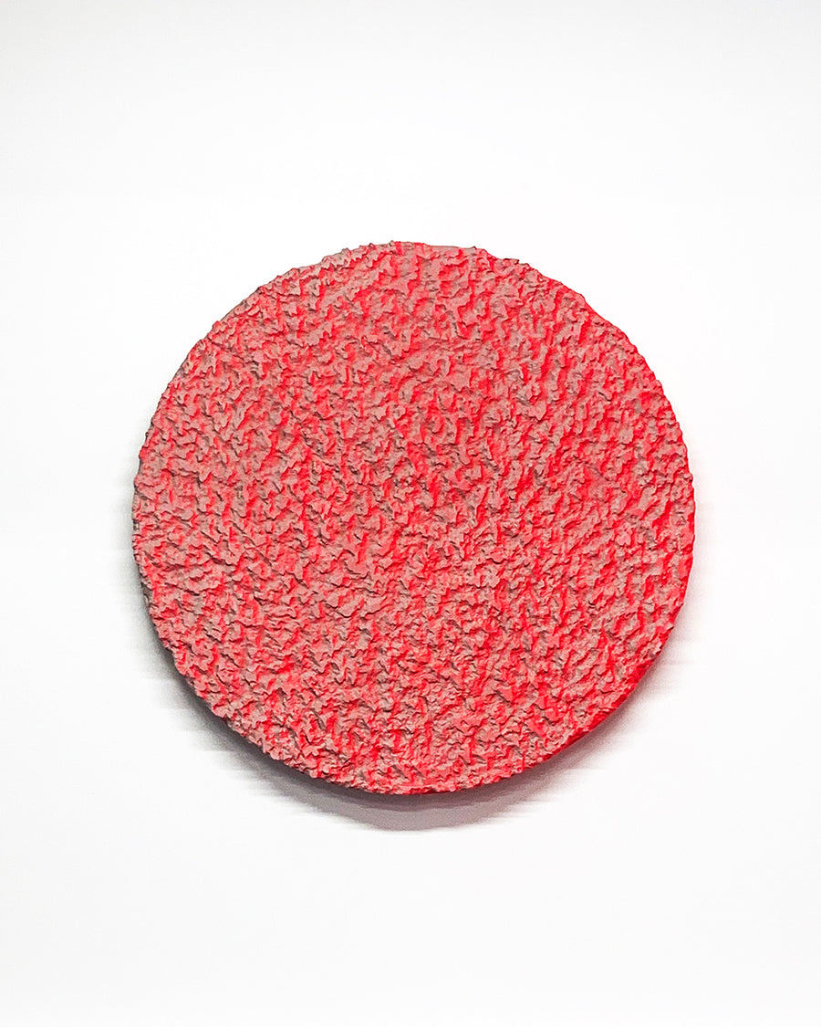 a red frisbee sitting on top of a white surface 