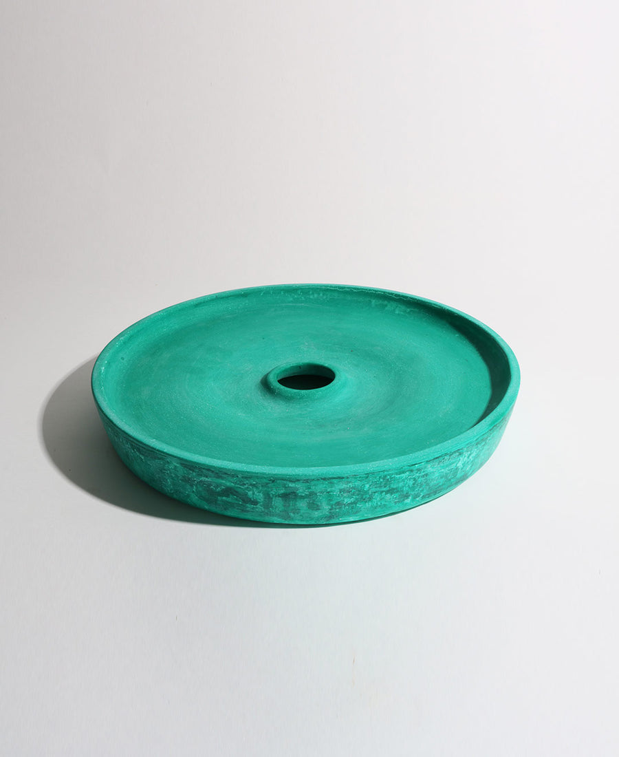 a green frisbee sitting on top of a white surface 