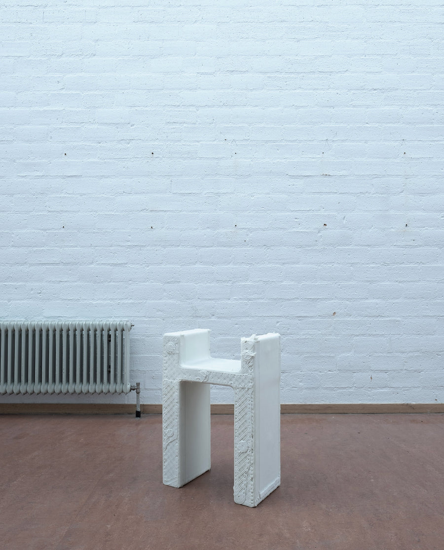 a white bench sitting on top of a hard wood floor 