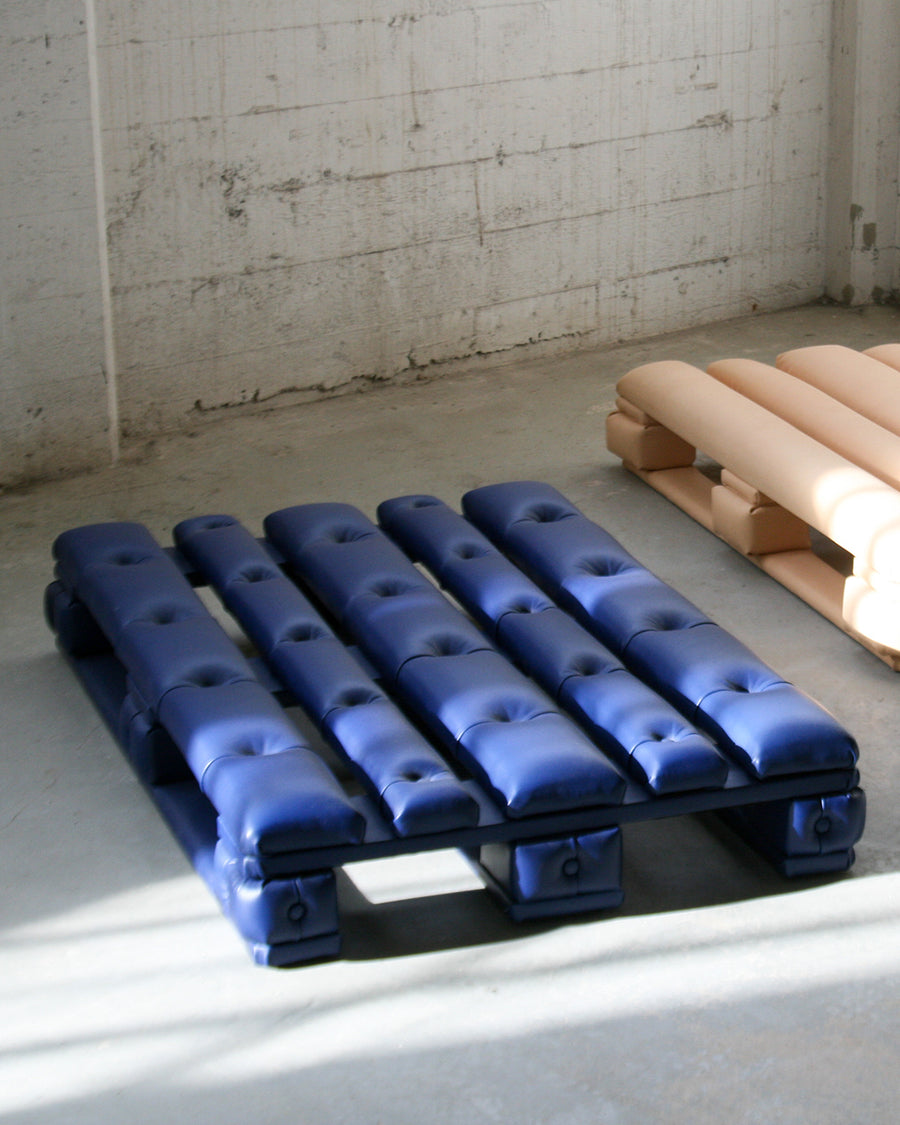 a blue couch with blue blue and white suitcases 