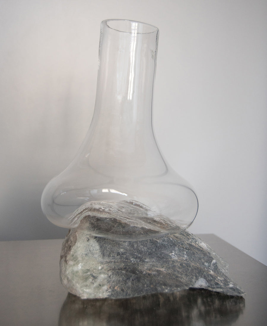 a glass vase sitting on top of a wooden table 