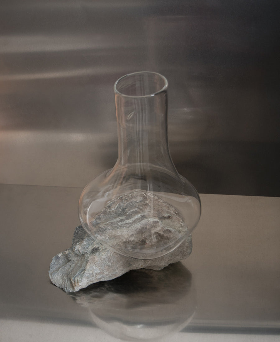 a glass vase sitting on top of a shelf 