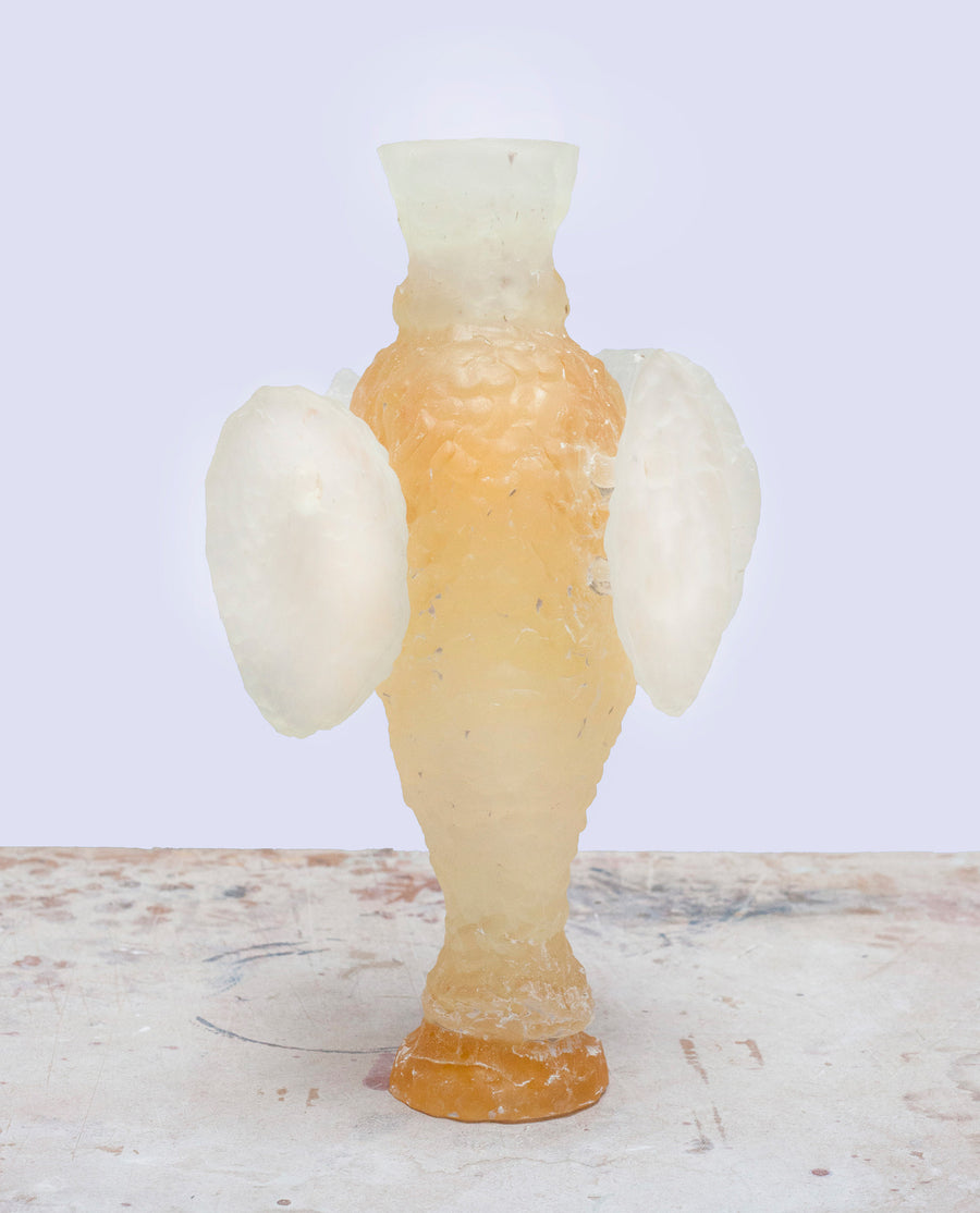a white vase sitting on top of a table 